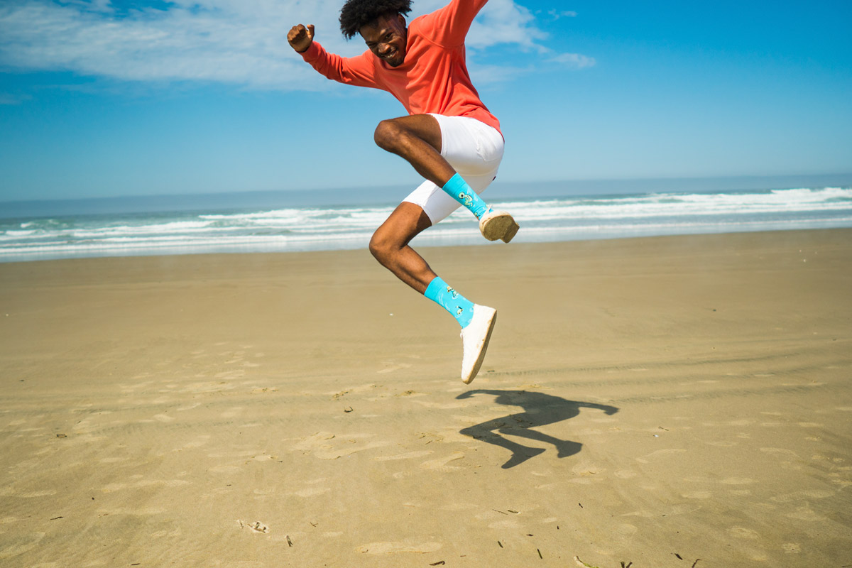 A jumping male model with his legs almost kicking the camera.